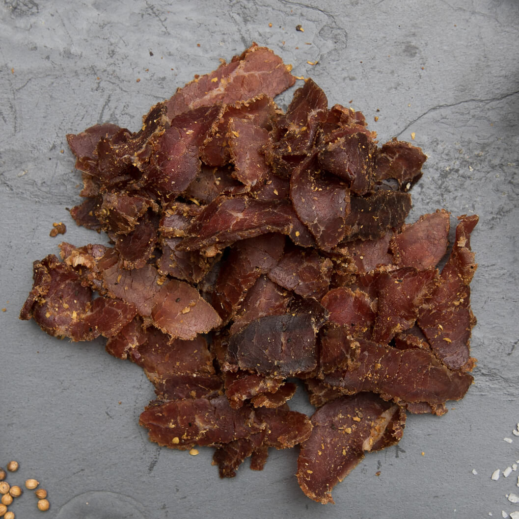 Ayoba Grass Fed Beef Biltong Slices on Slate.